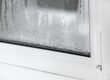 a plastic window with condensation of water on the glass Double glazed PVC window Concept: defective plastic window with condensation, temperature difference, cooling, humidity in the room